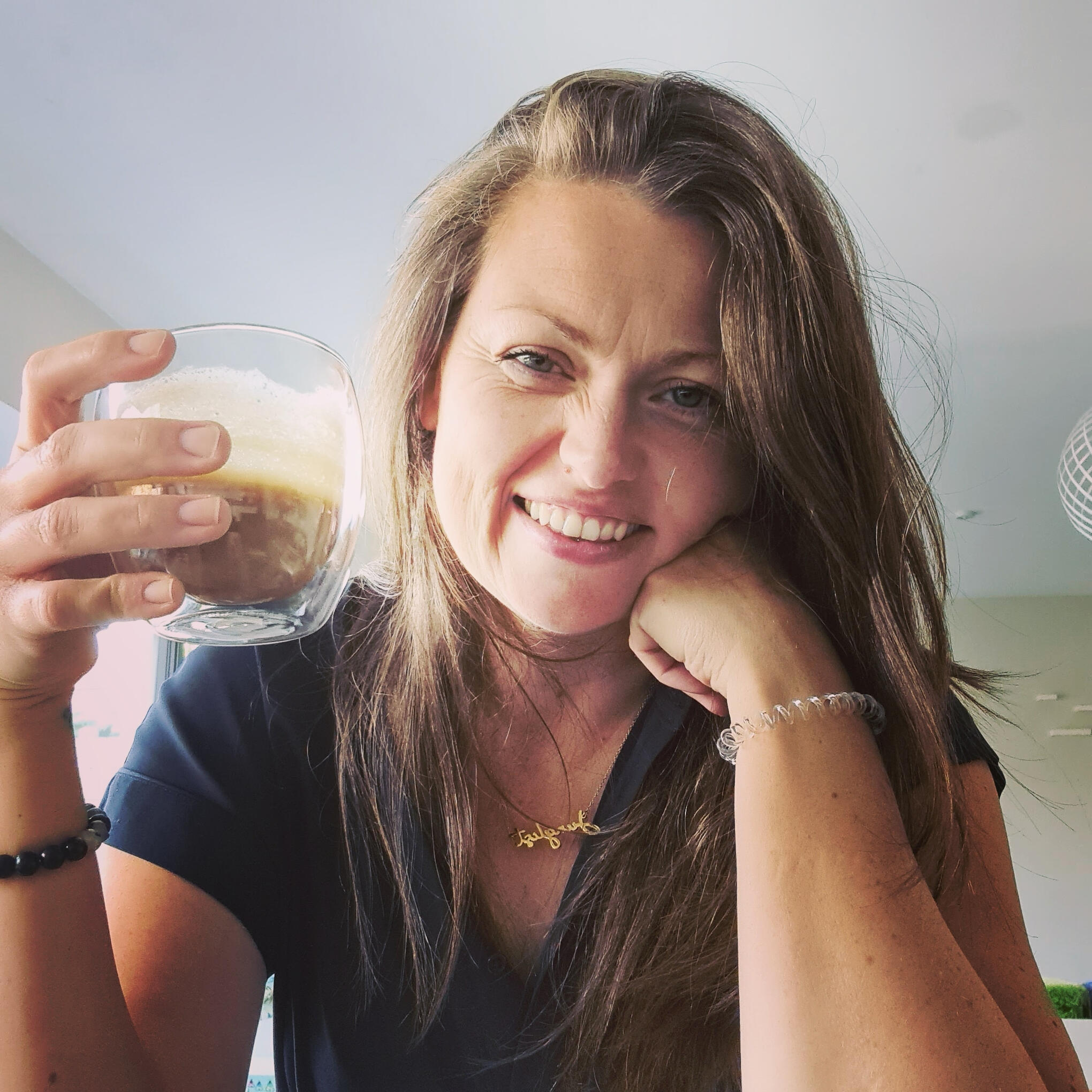 Lisa Giles - Pilates and Mindset Coach Lisa Giles - Pilates and Mindset Coach smiling in front of green wall